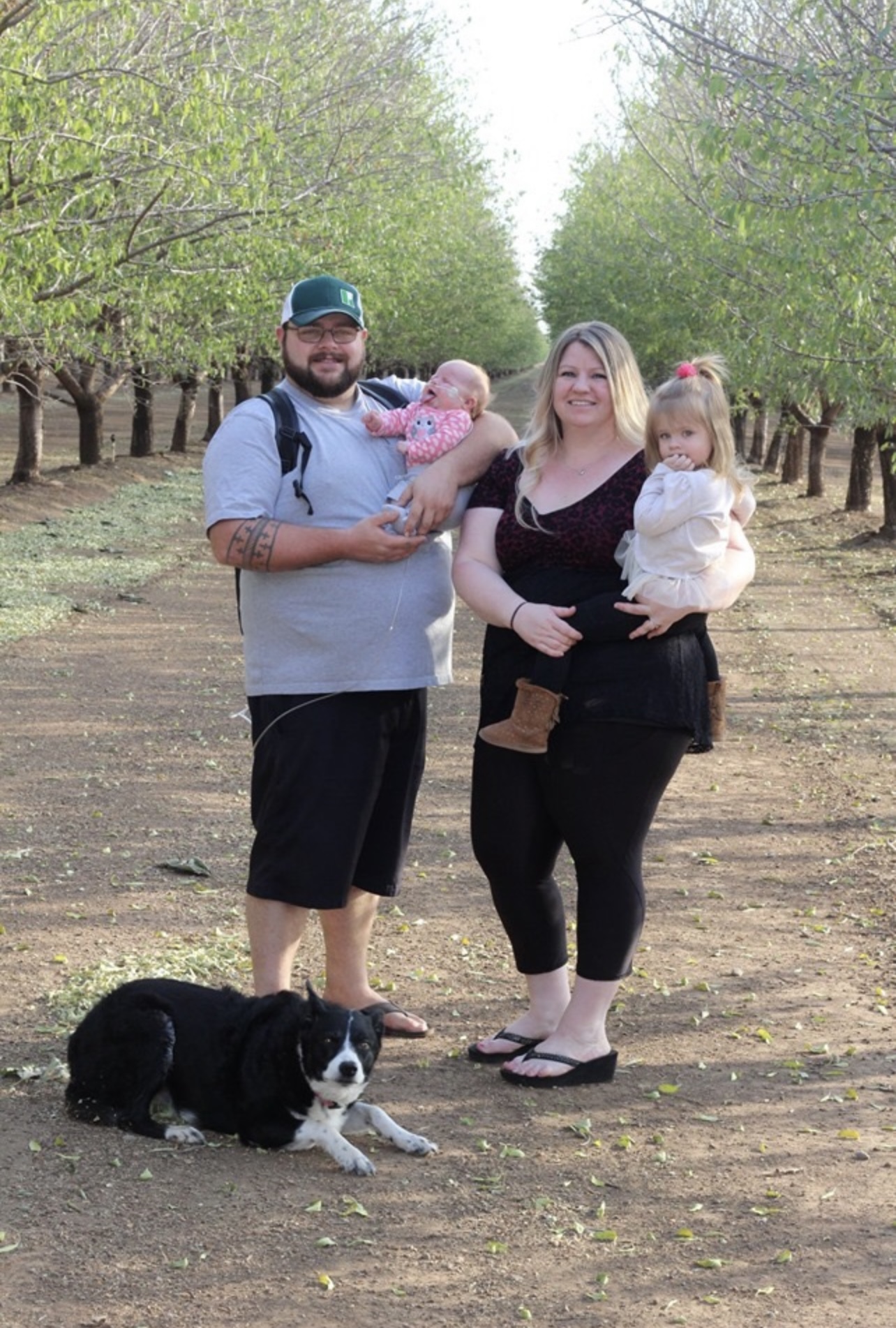 Hannah Ellis and family with an orchard in the background